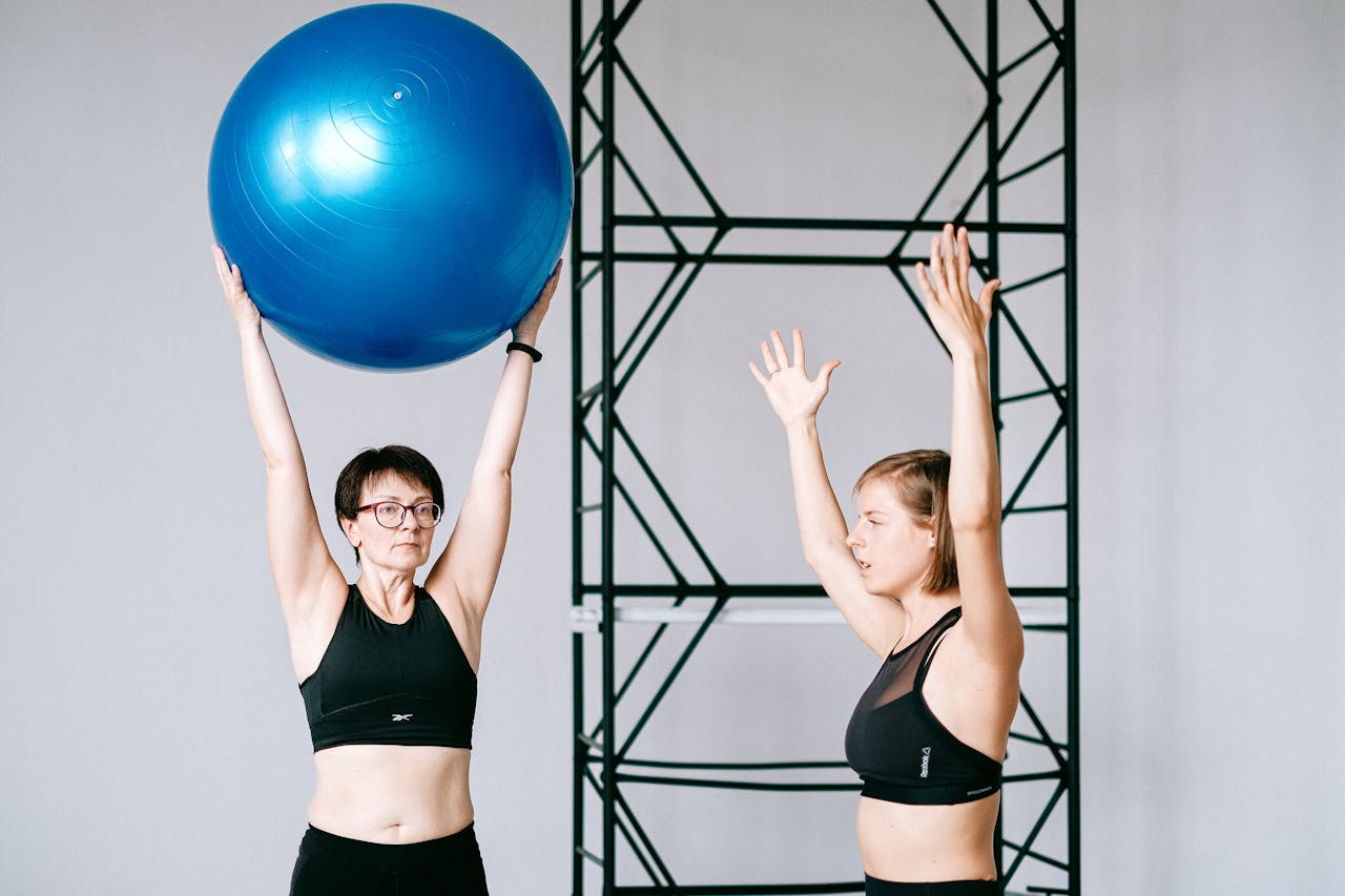 Women in Black Tank Top Training with a Gym Ball